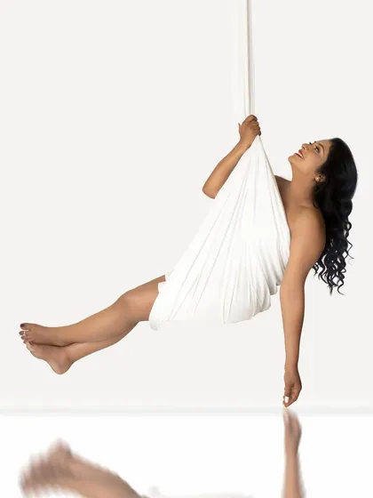 A whimsical and creative fine-art portrait. Using a white drape, I create the illusion of the mother-to-be floating effortlessly in a swing.