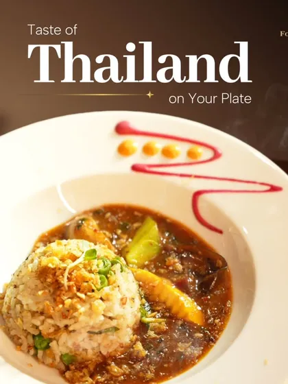 A taste of Thailand on your plate. This artfully presented dish features fragrant fried rice with a rich, savoury Thai curry, garnished with fresh herbs for an authentic flavour.