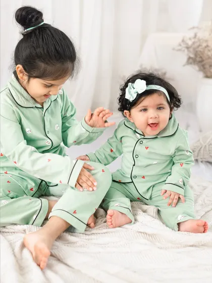 A sweet interaction between sisters during their pajama party themed photoshoot. The older sister's gentle touch is so loving.