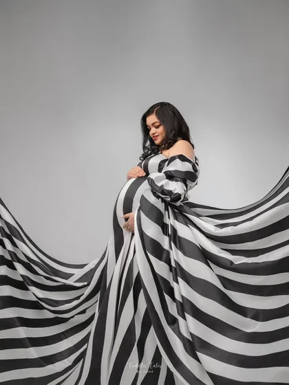 Inspired by high fashion, created for motherhood. This couture-inspired look with its bold stripes and dramatic flow is for the mother who sees her journey as a masterpiece. We will work together to create a concept that is as unique and iconic as you are.