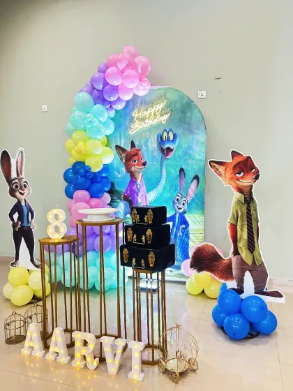 A Zootopia-themed 8th birthday party. This fun setup features life-sized cutouts of Judy Hopps and Nick Wilde, a colorful balloon arch, and a large light-up number '8'.