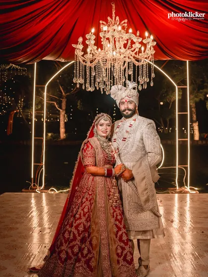 A regal portrait of the bride and groom on their wedding day. We excel at creating these classic, posed shots that highlight the intricate details of the wedding attire and the grandeur of the decor.