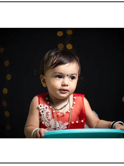 A simple and elegant studio portrait. The dark background and soft lighting create a classic look that focuses all attention on the child.