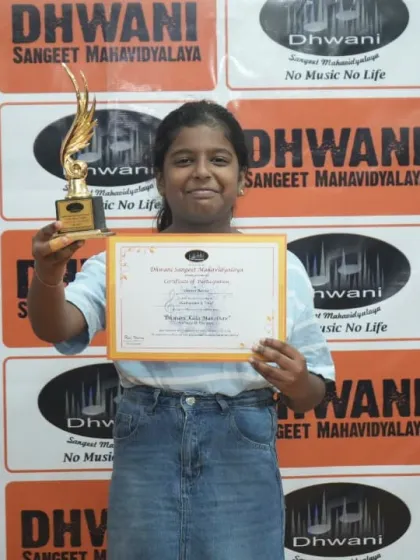 A student proudly holds her certificate and trophy.