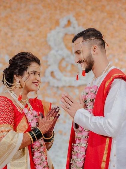 A beautiful moment between the bride and groom. Her elegant updo is visible from the side, complementing her traditional attire.