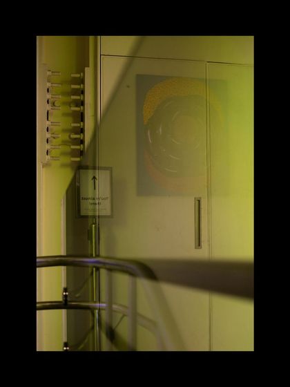 Light and shadow play across a doorway and signage inside the Museum of Art and Photography (MAP). The design carefully considers how light interacts with surfaces to create atmosphere and guide movement through the space.