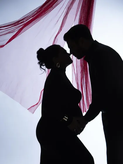 A silhouette is a beautiful way to capture intimacy. Here, a hint of red fabric adds a touch of passion to this otherwise classic black and white couple portrait.