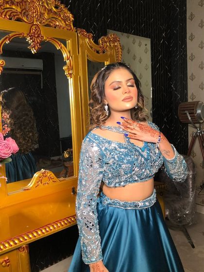 A close-up of this glamorous party look. The blue sequined top is paired with soft, glowing makeup.