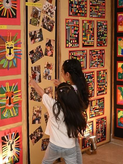 Two young artists excitedly pointing out details in the artwork on display. The exhibition is a huge source of inspiration for all my students.