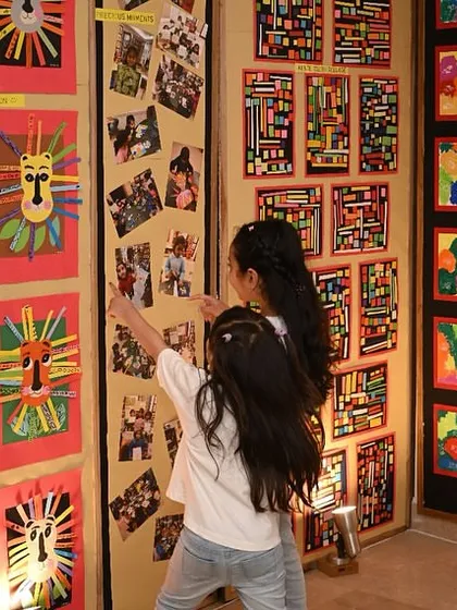 Students exploring the gallery walls, pointing out their friends' work and their own. Our exhibition is a truly interactive and inspiring event for the children.