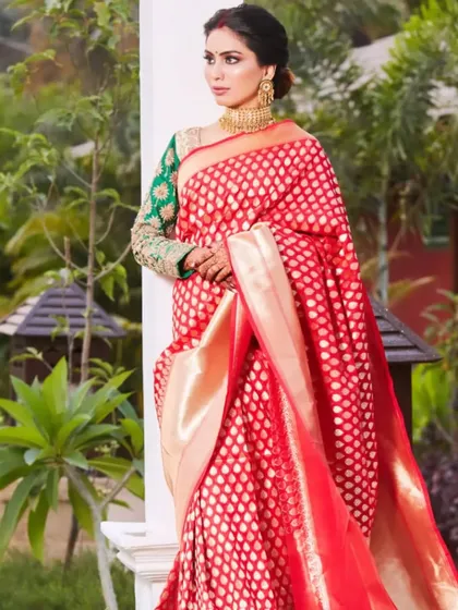 A full portrait of the bride in her gorgeous red reception saree. The makeup, hair, and styling all come together to create an image of pure elegance and grace.