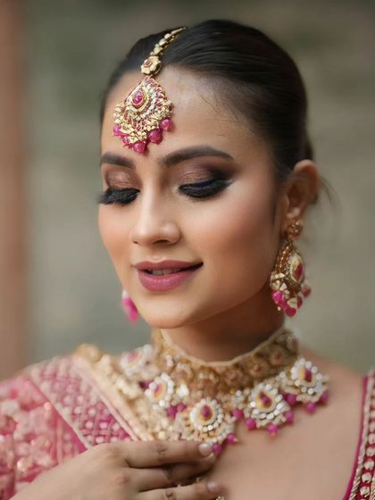 An eyes-closed shot to highlight the dark, blended smokey eye, which contrasts beautifully with the pink outfit.