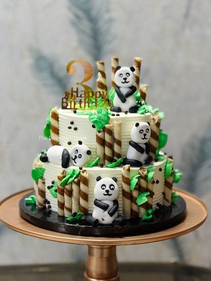 This two-tier panda theme cake is one of my favorites for kids' birthdays. It features cute, handcrafted fondant pandas, chocolate wafer sticks that look like bamboo, and a delicious chocolate mousse filling.