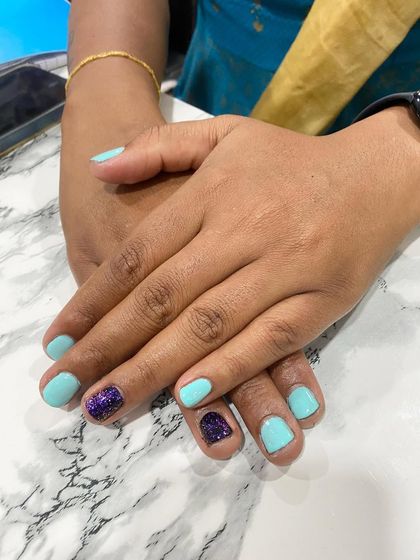 A simple yet cute set of short nails in a lovely turquoise color with a single purple glitter accent nail.
