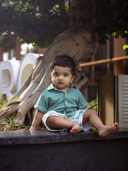 A solo shot of the adorable toddler from the Church Street session, sitting under a tree.
