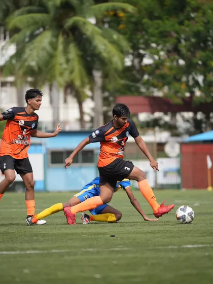 Battling through a tough tackle to maintain possession, highlighting the resilience and fight in our team.