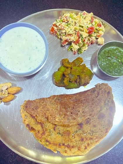 Here's what breaking a 17-hour fast looks like. A moong dal and almond flour chila, paneer bhurji, cucumber raita, and soaked nuts. This meal is designed to be high in protein and healthy fats to properly refuel the body.