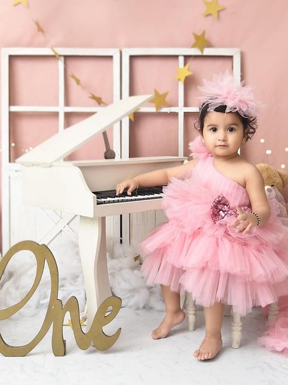 A little pianist playing a sweet melody. Her gorgeous pink dress and the elegant white piano make for a sophisticated and adorable birthday photo.