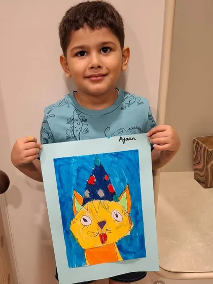 This is the moment I work for. The pure pride and joy on this young artist's face after independently creating his own party cat artwork is what our classes are all about.