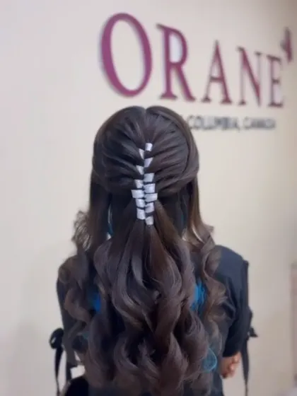 The final look of the open hairstyle with a woven ribbon detail, perfect for a glamorous party.