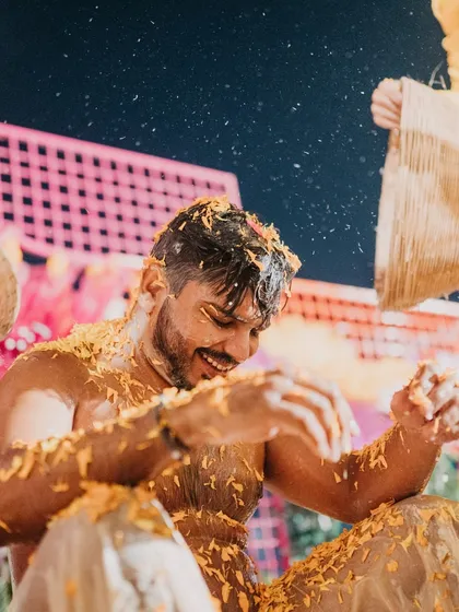 The groom enjoying his Haldi ceremony, getting showered with marigold petals by his friends. The energy and happiness in these moments are what make weddings so special.