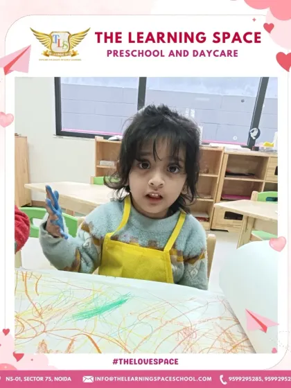 A child proudly shows off her paint-covered hands. We celebrate the messy process of creation, as it's a sign of joyful, uninhibited learning.
