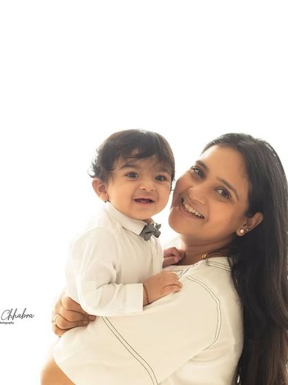 A classic mother and son portrait from a first birthday session. The clean, bright studio background keeps the focus on their happy connection.