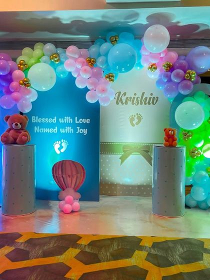 Another view of the main stage for Krishiv's naming ceremony, showcasing the full scope of the balloon arches and themed backdrops. We use lighting to enhance the colors and create a magical ambiance.