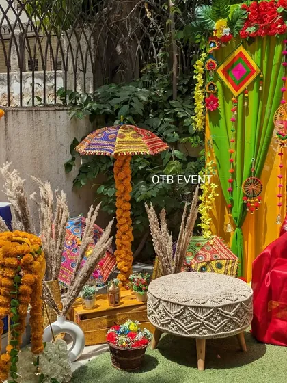 A closer look at the seating area for the Mehendi function, highlighting the mix of textures from the woven stool, pampas grass, and vibrant drapes.
