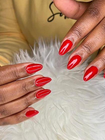 A simple yet stunning set of bright red, almond-shaped gel nails. A classic look that never fails.