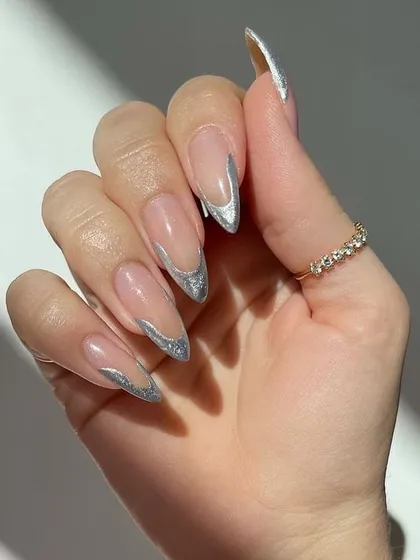 This is my modern take on a classic. A sharp, silver glitter French tip on perfectly shaped almond extensions for a look that is both elegant and glamorous.