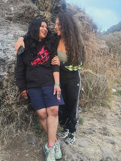 A candid moment of friendship and support between two participants on a mountain trail. Our retreats foster a safe space for genuine connection and shared experiences.