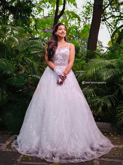 A radiant bride in a beautiful garden setting. This white ball gown with its simple, elegant design is perfect for an outdoor Christian wedding.