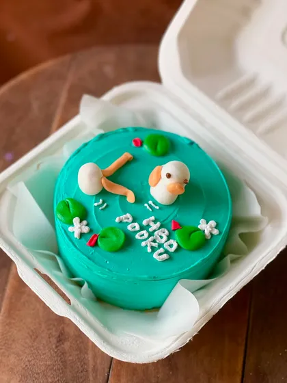 A super cute birthday cake for Pooku, featuring a little duck swimming in a pond with lily pads. The 3D elements make this design extra special.