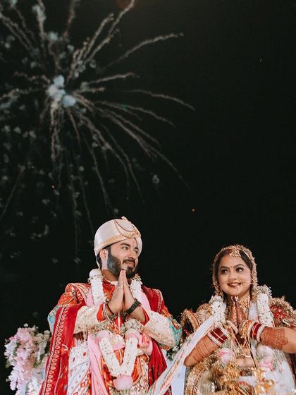 The couple looks up at the fireworks, a moment of shared wonder and celebration on their wedding night.