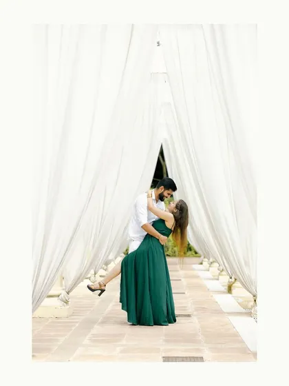 A timeless and romantic portrait of a couple sharing a gentle moment. The flowing white drapes create a dreamy, ethereal frame, perfect for a pre-wedding photoshoot that feels both classic and modern.