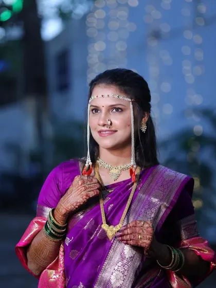 A classic Punyavachan look with the traditional mundavalya. The bride's purple saree and simple makeup create a look of serene beauty.