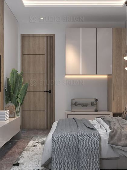 A full view of a bedroom in Shiv Vihar, showcasing a mix of wood textures on the TV wall and door, paired with clean, white furniture.