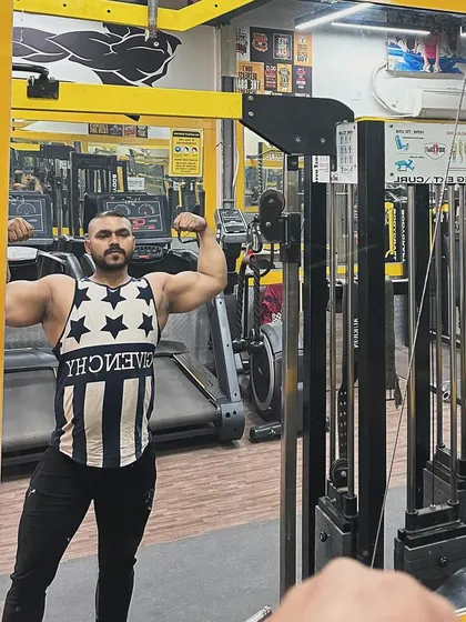 A classic front double biceps pose in the mirror. This is a great way to assess arm size, symmetry, and overall upper body development.