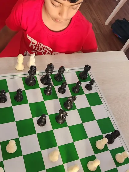 A close up of a young boy studying the board. Every game is a new puzzle to solve, and we guide our students in developing their problem solving skills.