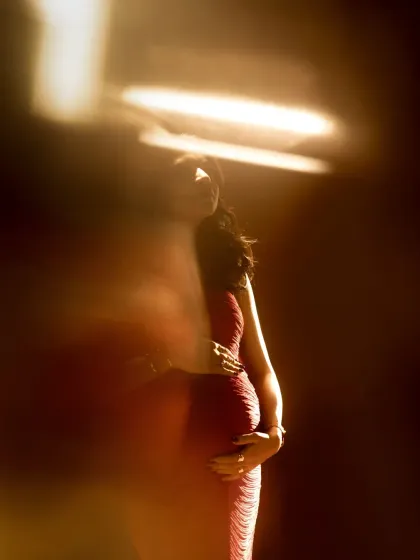 A silhouette of motherhood. This abstract and artistic photo uses light and shadow to create a mysterious and beautiful outline of the pregnant form, focusing on shape and emotion rather than detail.