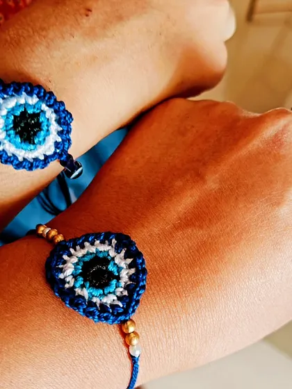 A customer photo showing two of my evil eye crochet rakhis being worn. It is always wonderful to see my creations being loved.