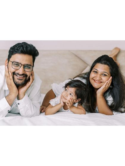 A family lying on the bed, posing for a fun photo. Even in a posed shot, I aim for genuine smiles and a relaxed feel.