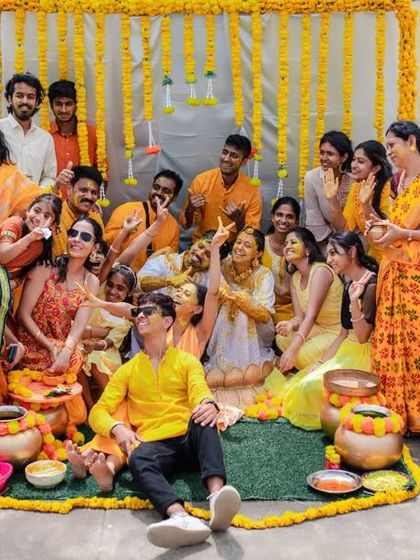 A wide shot of a rooftop Haldi party, showing the entire group celebrating together. We capture the full scale and energy of your events.