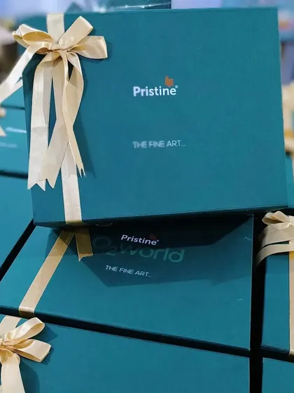 Stacks of elegant teal boxes with gold ribbons, designed and curated for Pristine Developers. Corporate hampers like these are a powerful tool for reinforcing brand identity and showing client appreciation.