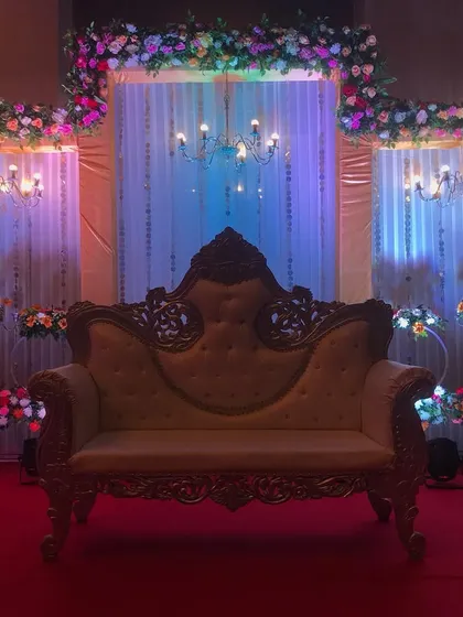 A similar stage setup, but with a gold-carved sofa and dramatic blue and purple lighting to create a different, more regal mood.