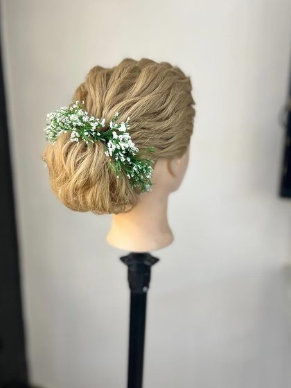 A soft, romantic low bun with baby's breath, a popular choice for Christian brides or minimalist aesthetics.