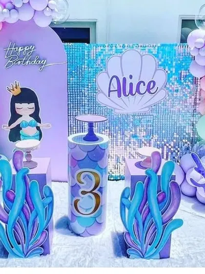 An under-the-sea themed 3rd birthday party with a shimmer wall, custom backdrop, and themed props.