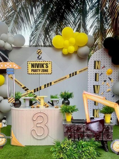 The full construction party setup, complete with a crane, excavator, and a "Party Zone" sign. The yellow, black, and grey color scheme is consistent across all elements, from the balloons to the props.