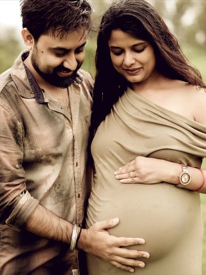 A warm and loving portrait of the couple embracing the baby bump together. Their gentle expressions show their shared love and anticipation for their little one.